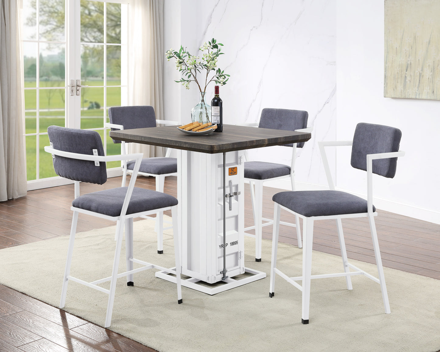 Four grey upholstered bar stools with white metal frames surrounding a dark wood top pub table