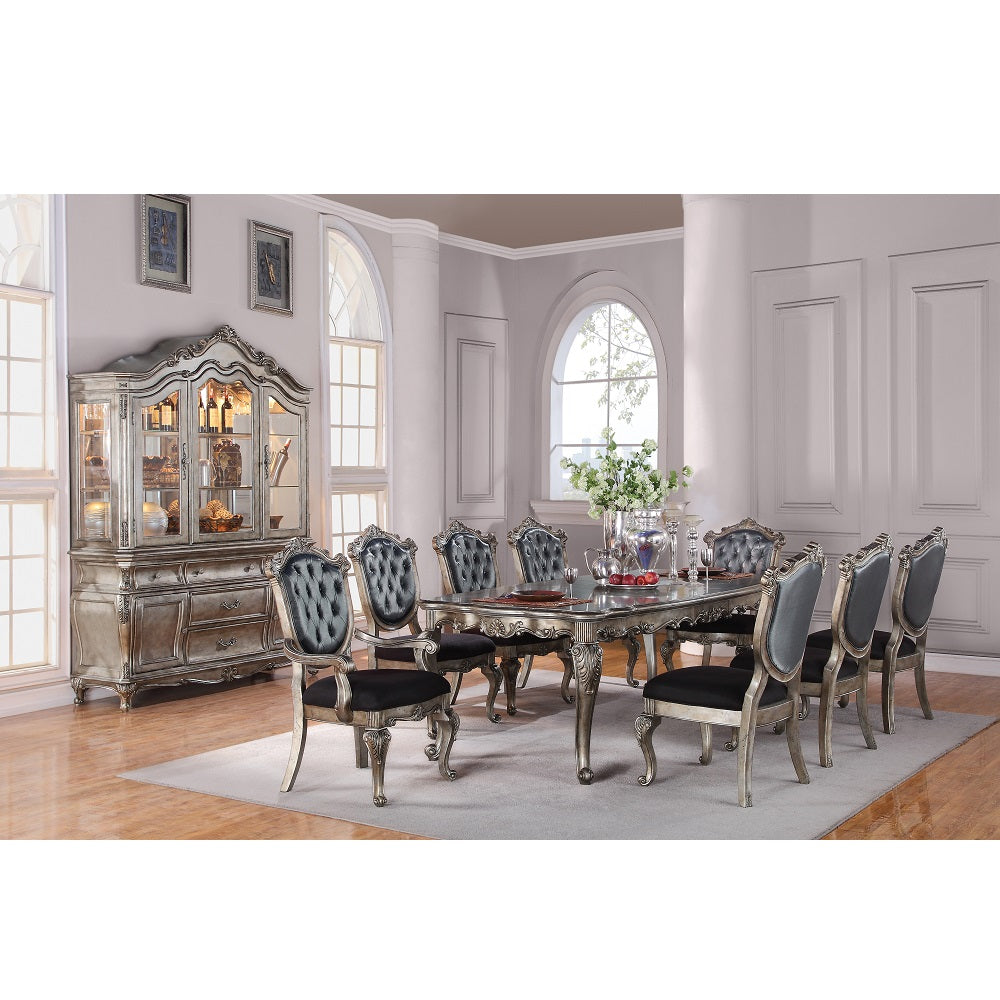 Ornate silver dining set featuring a large table and eight upholstered chairs