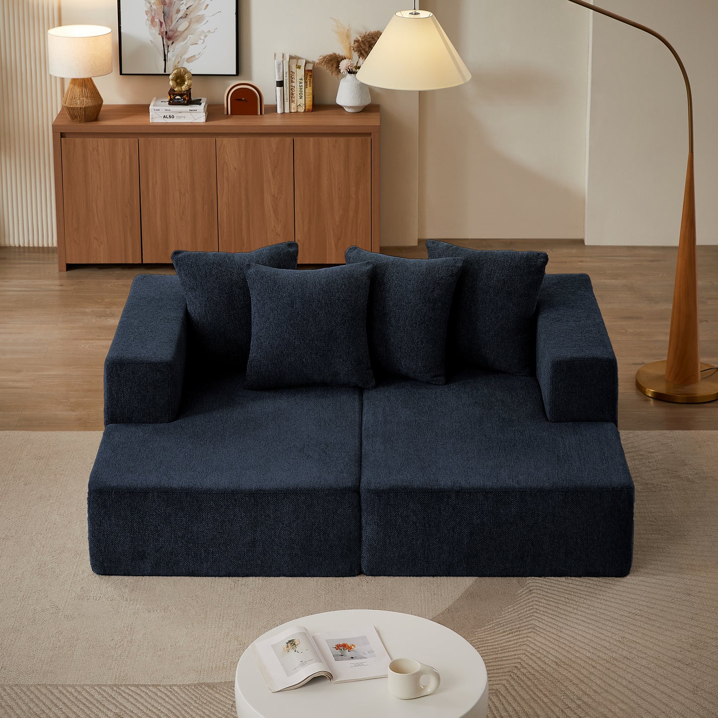 Navy blue modular sofa with plush fabric upholstery and four matching throw pillows