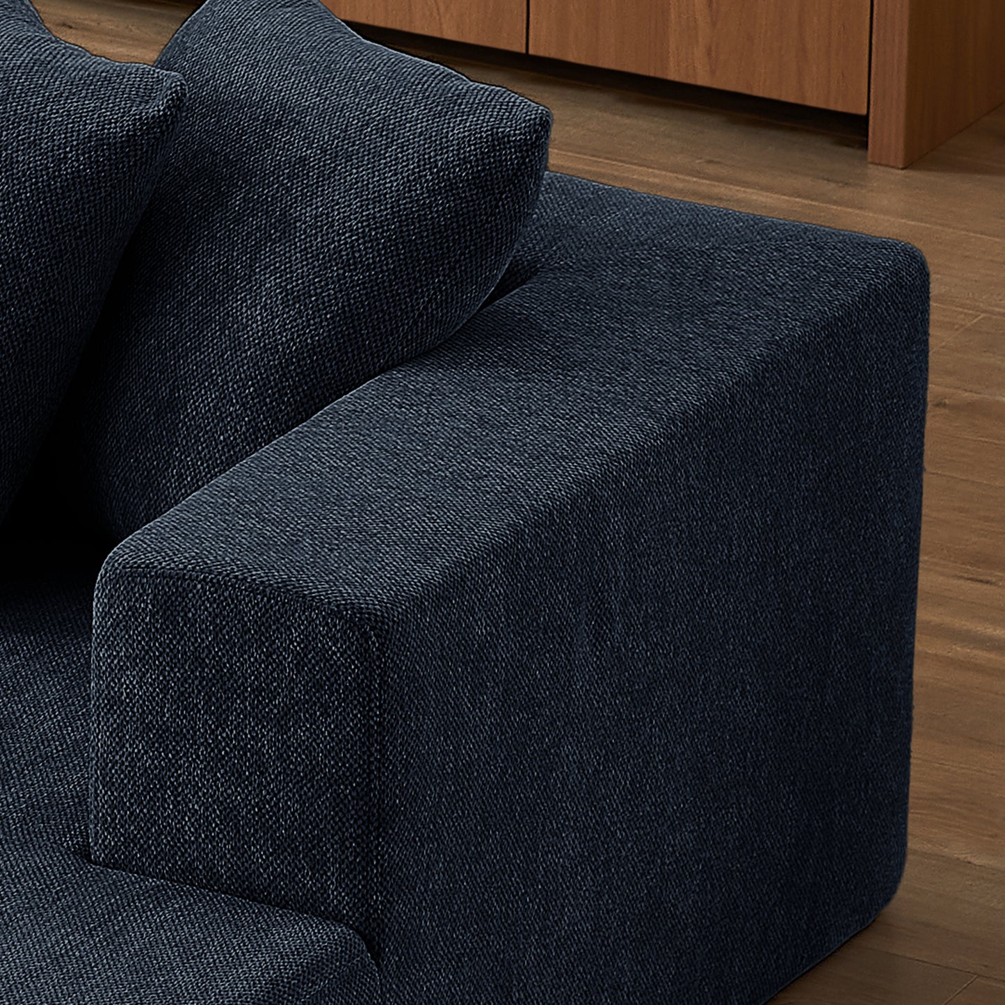 Closeup of a dark navy fabric armchair with visible texture and depth