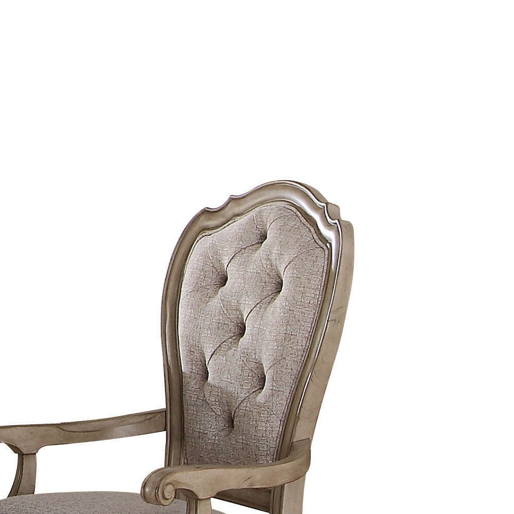 Tufted grey fabric armchair with carved distressed wood frame