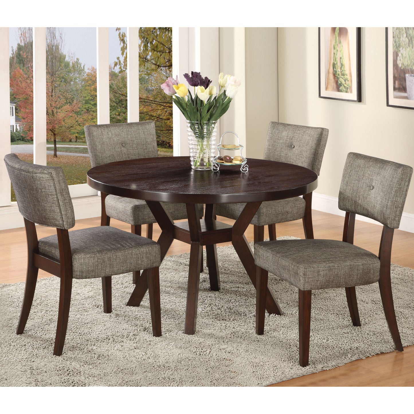 Round dining table with dark wood finish and four grey upholstered chairs
