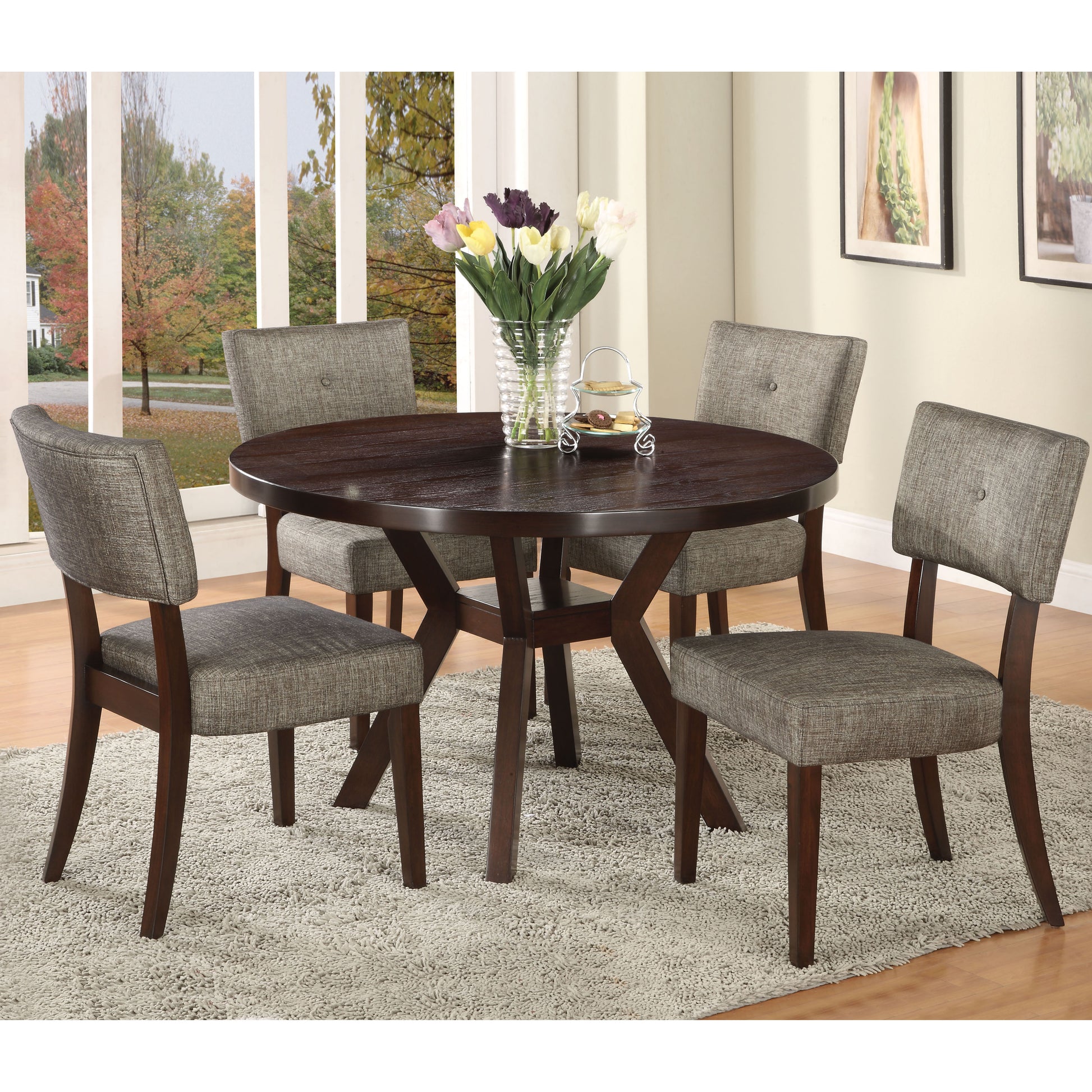 Round dining table with dark wood finish and four grey upholstered chairs
