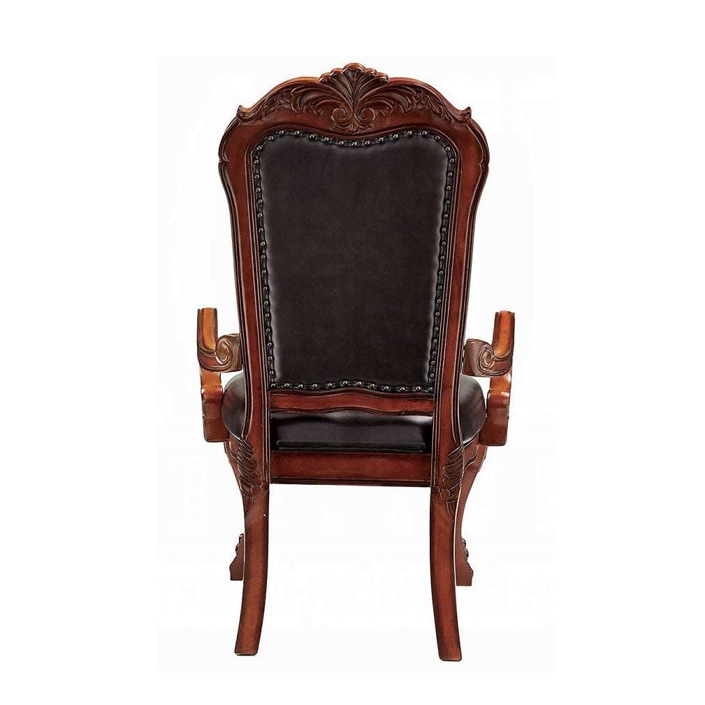 Ornate dark wood armchair with carved detailing and brown leather seat