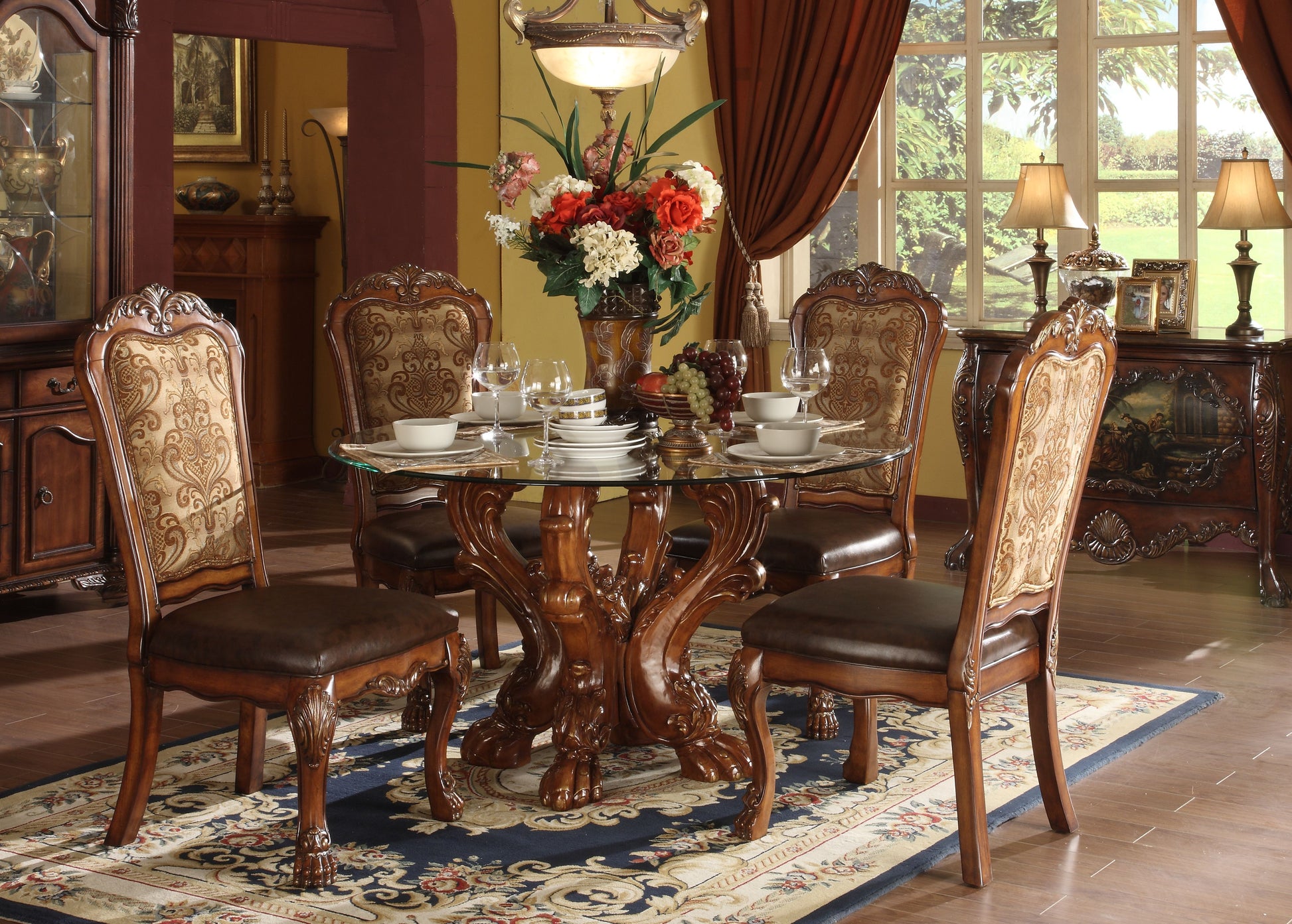 Round glass dining table with ornate wooden base and matching carved chairs set for four