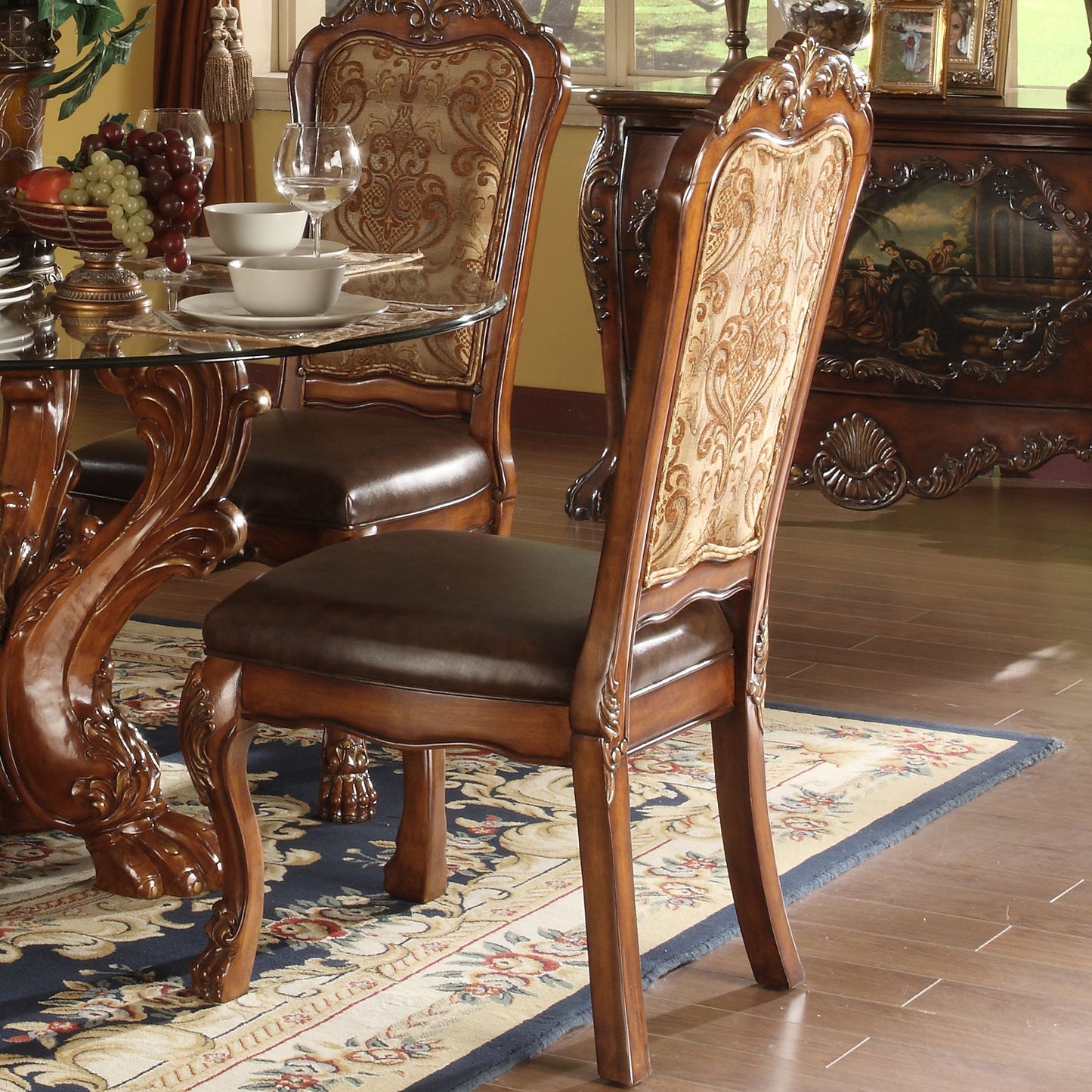 Ornate carved wood dining chair with ornate damask upholstery and dark leather seat