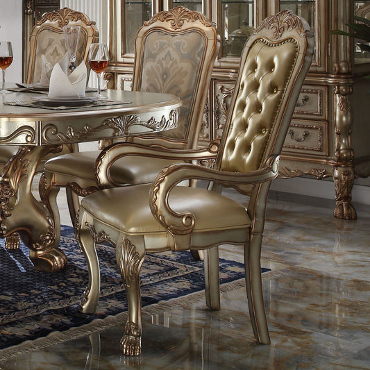 Ornate gold dining chair with tufted champagne leather upholstery and carved wood accents