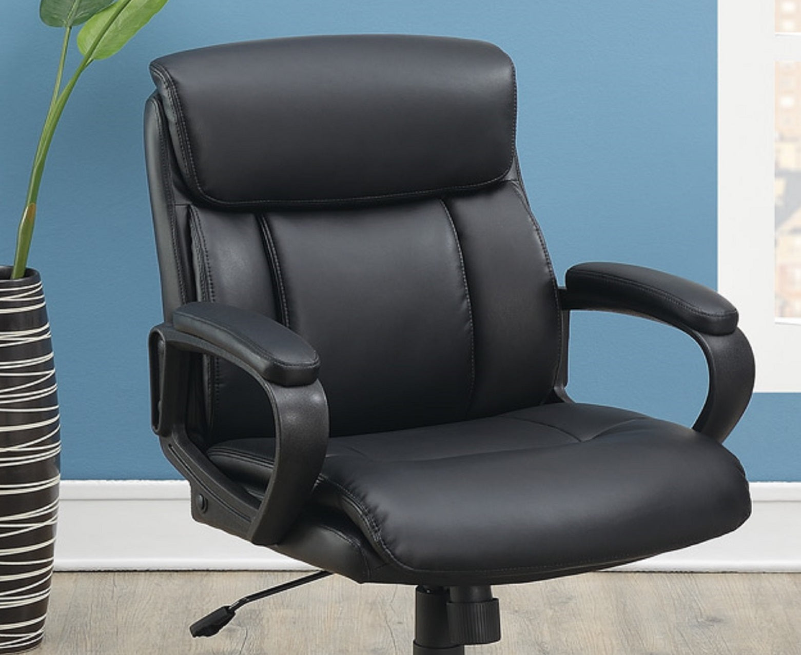 Black faux leather executive chair with plush cushioning for ultimate comfort