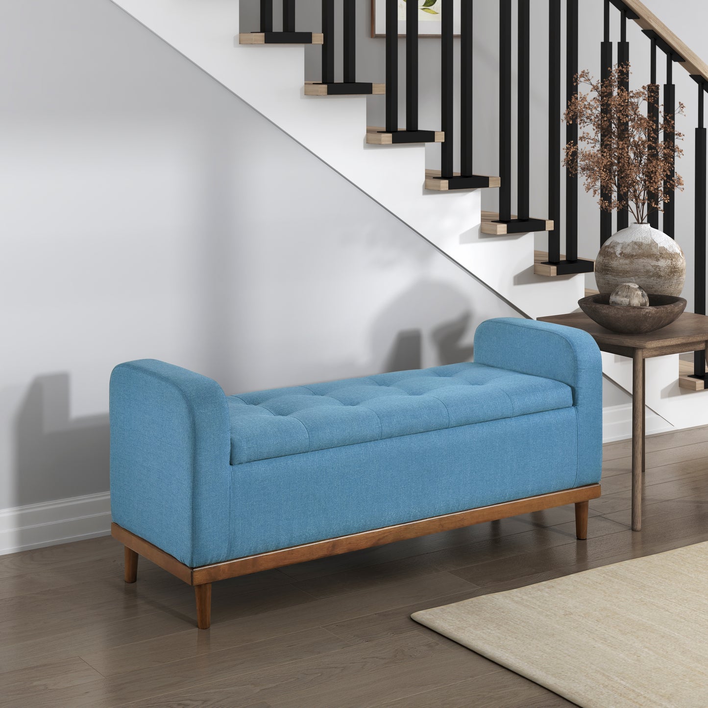 Tufted blue storage bench with wooden legs and a modern design