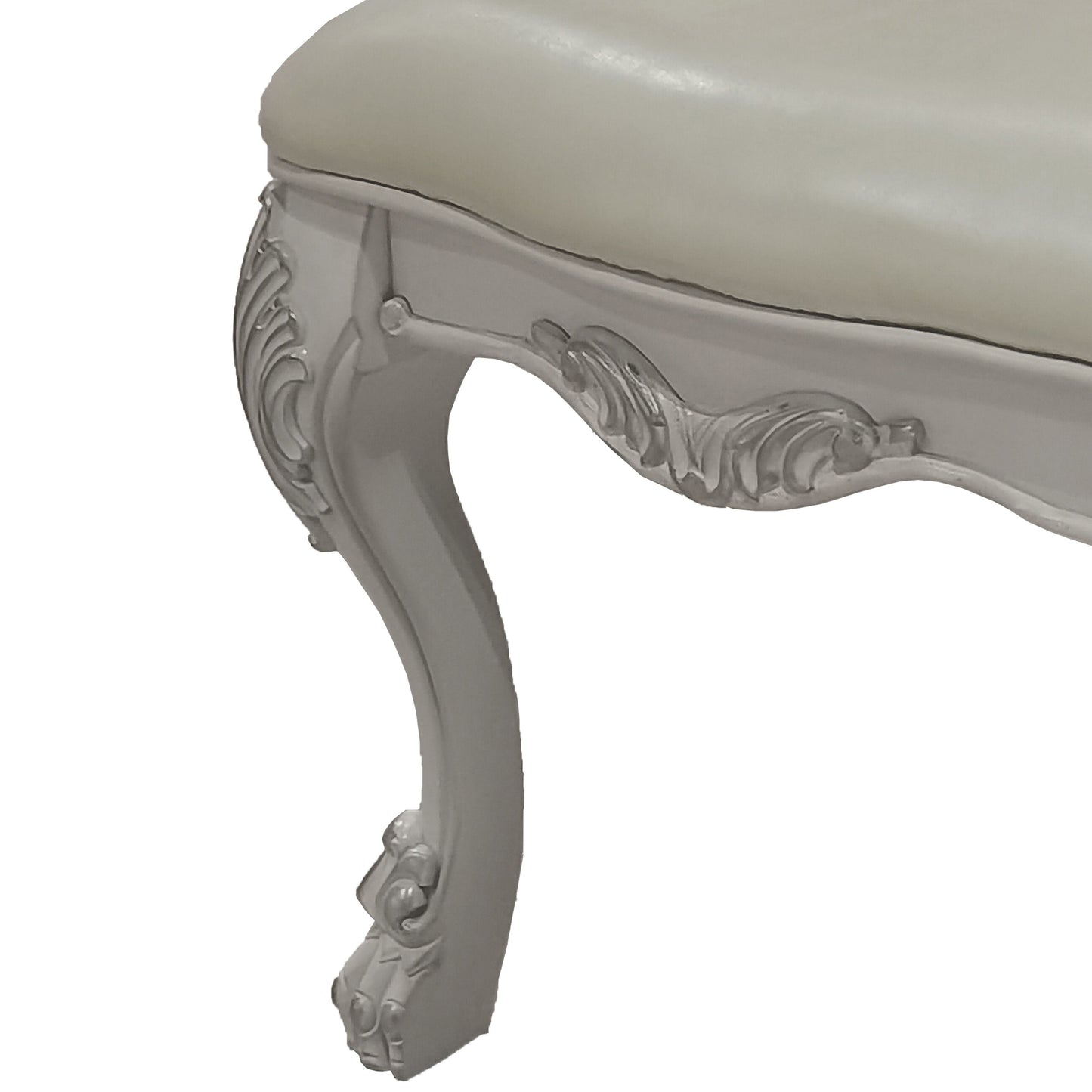Cream upholstered ottoman with ornate carved light gray legs