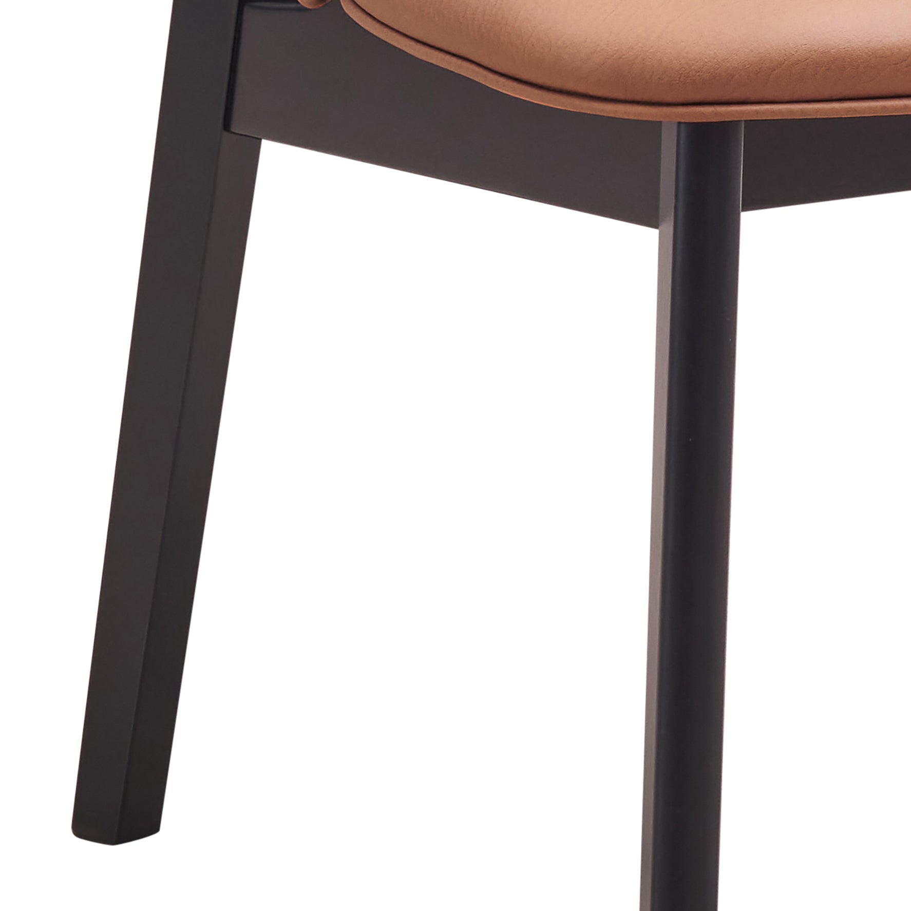 Closeup of a modern black metal chair leg with a caramel leather seat detail