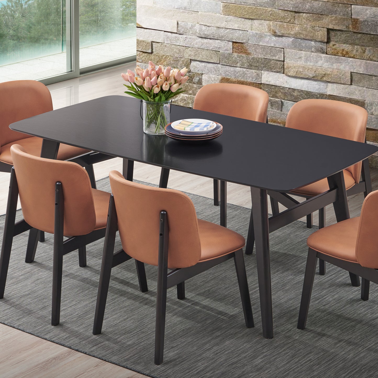Modern black dining table with tan faux leather chairs and tulip centerpiece