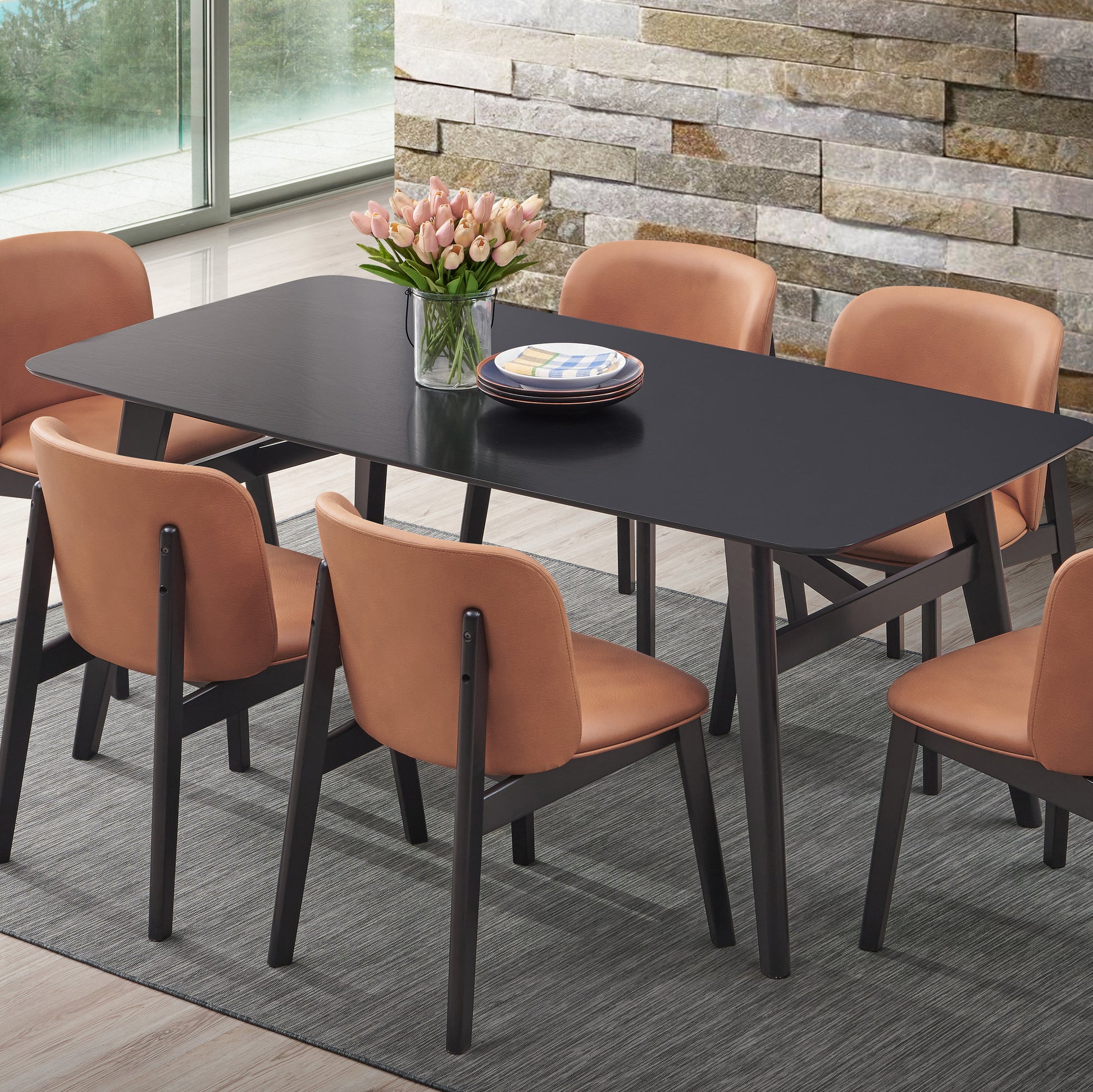 Modern black dining table with tan faux leather chairs and tulip centerpiece