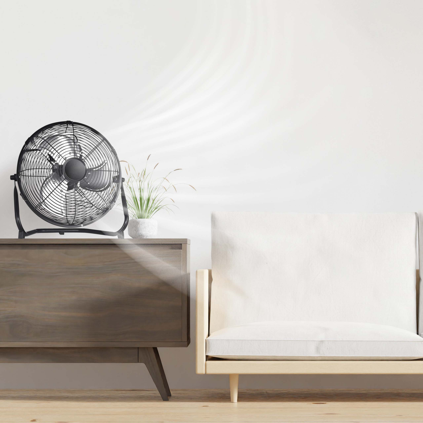 Black metal floor fan on wooden cabinet creating airflow in room