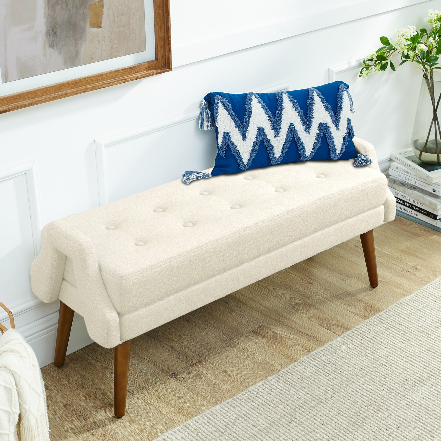 Cream tufted bench with wooden legs and blue chevron pillow
