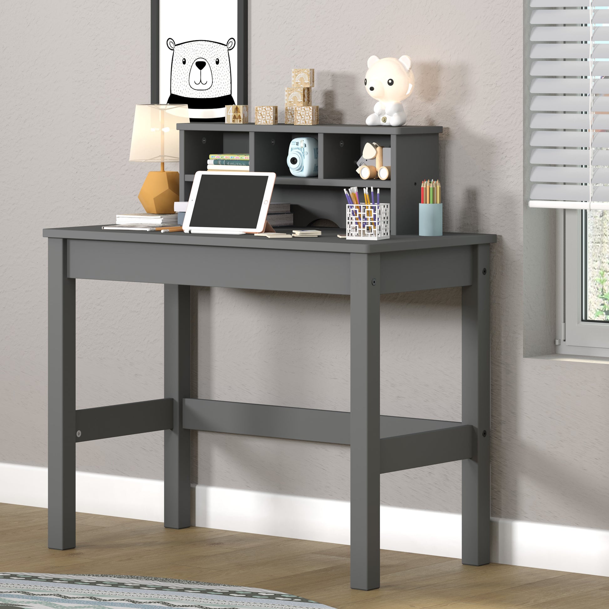 Grey wooden childrens desk with hutch tablet and decorative items for kids room