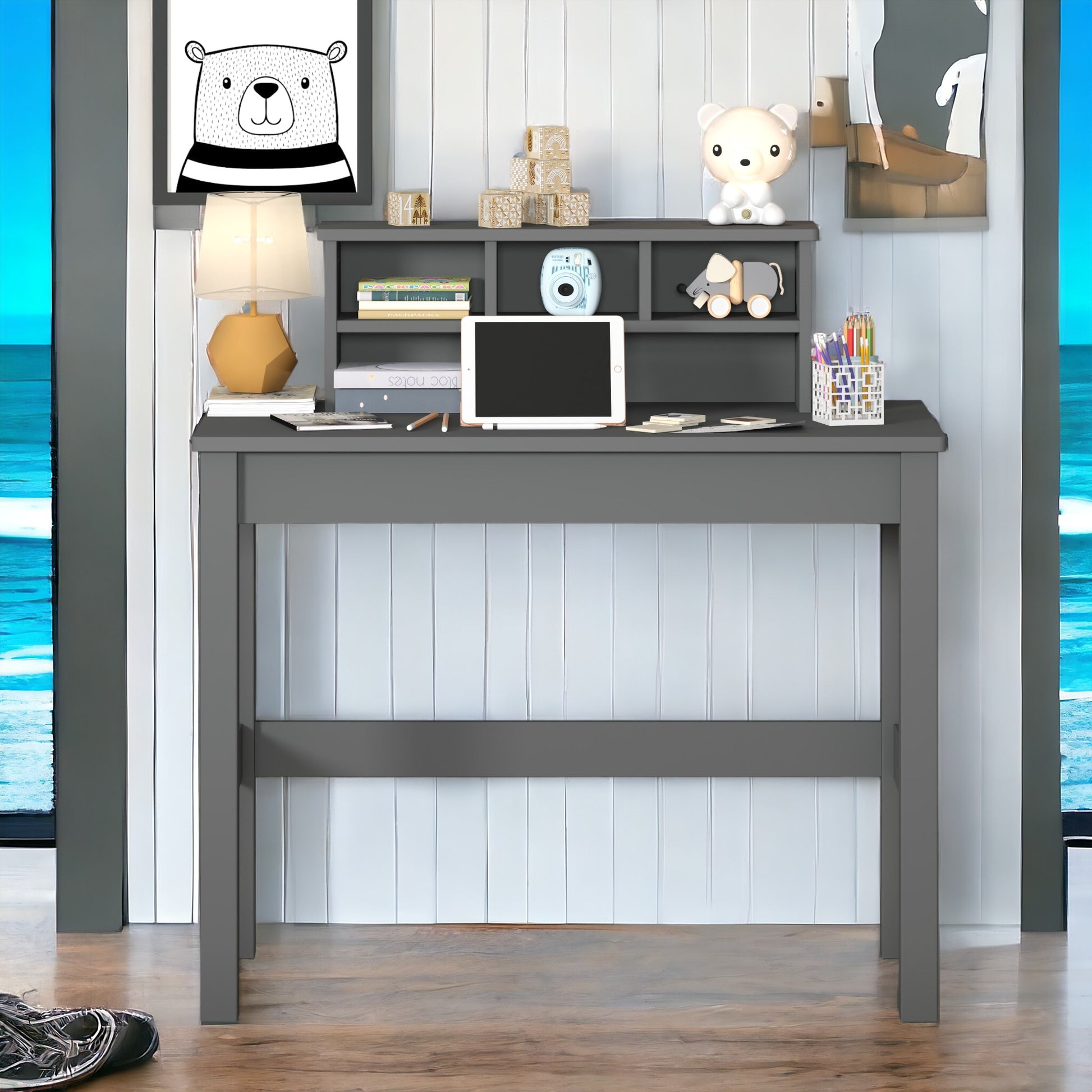 Gray wooden student desk with shelves organized for schoolwork with tablet and books