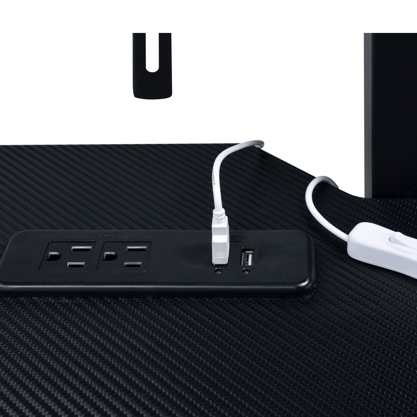 Black carbon fiber texture desk with integrated power strip featuring  outlets and USB ports