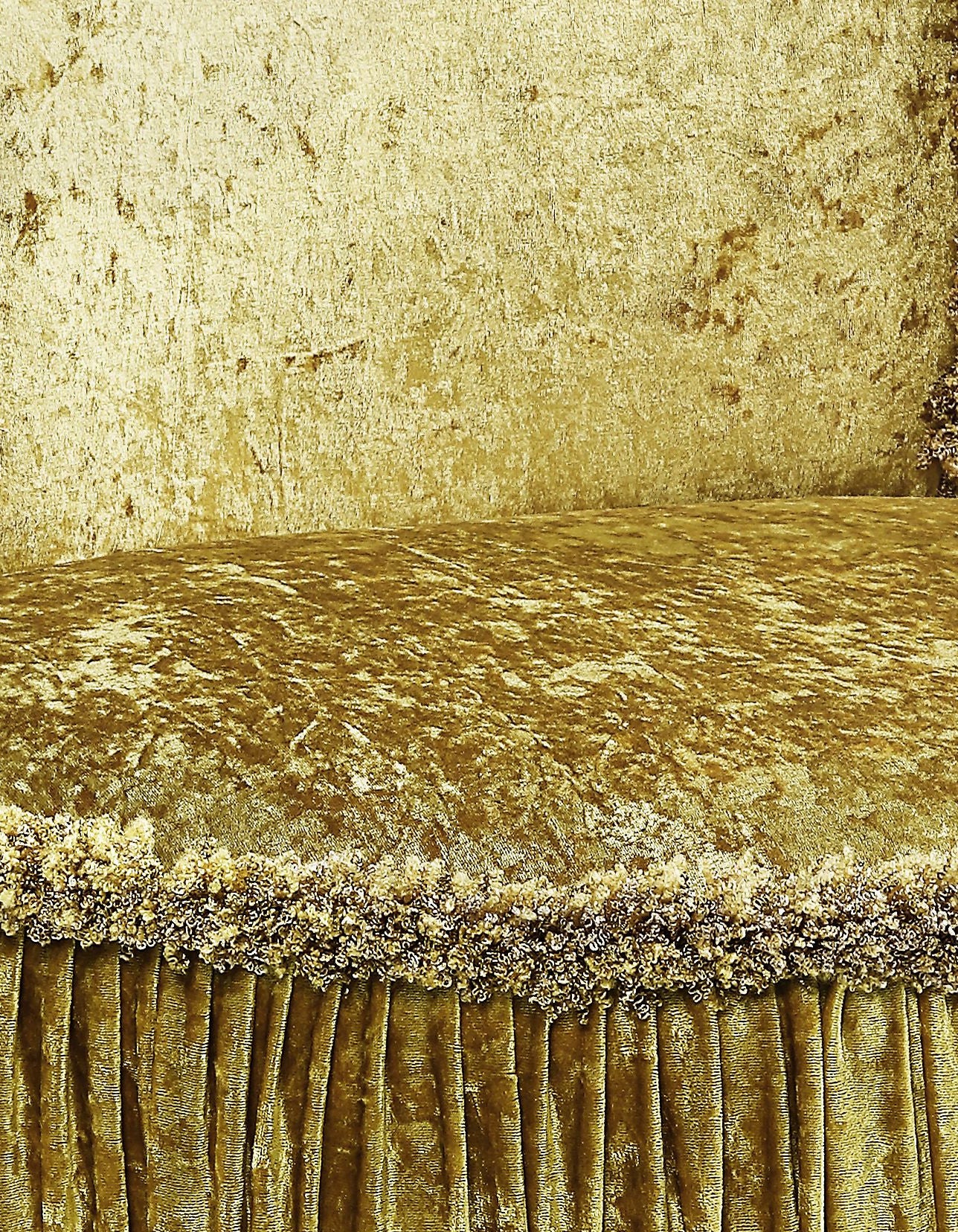 Antique gold velvet armchair with ornate fringe and pleated skirt rich texture