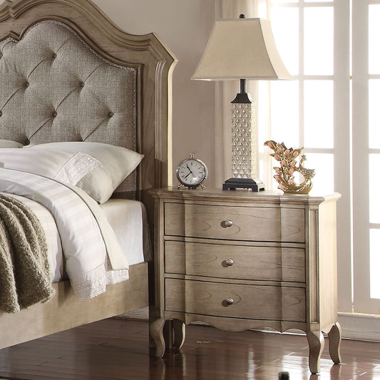 Threedrawer wooden nightstand with silver pulls complementing a classic bedroom set