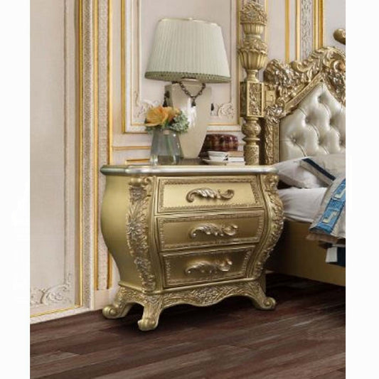 Ornate gold nightstand with three drawers featuring carved detailing and elegant scrollwork