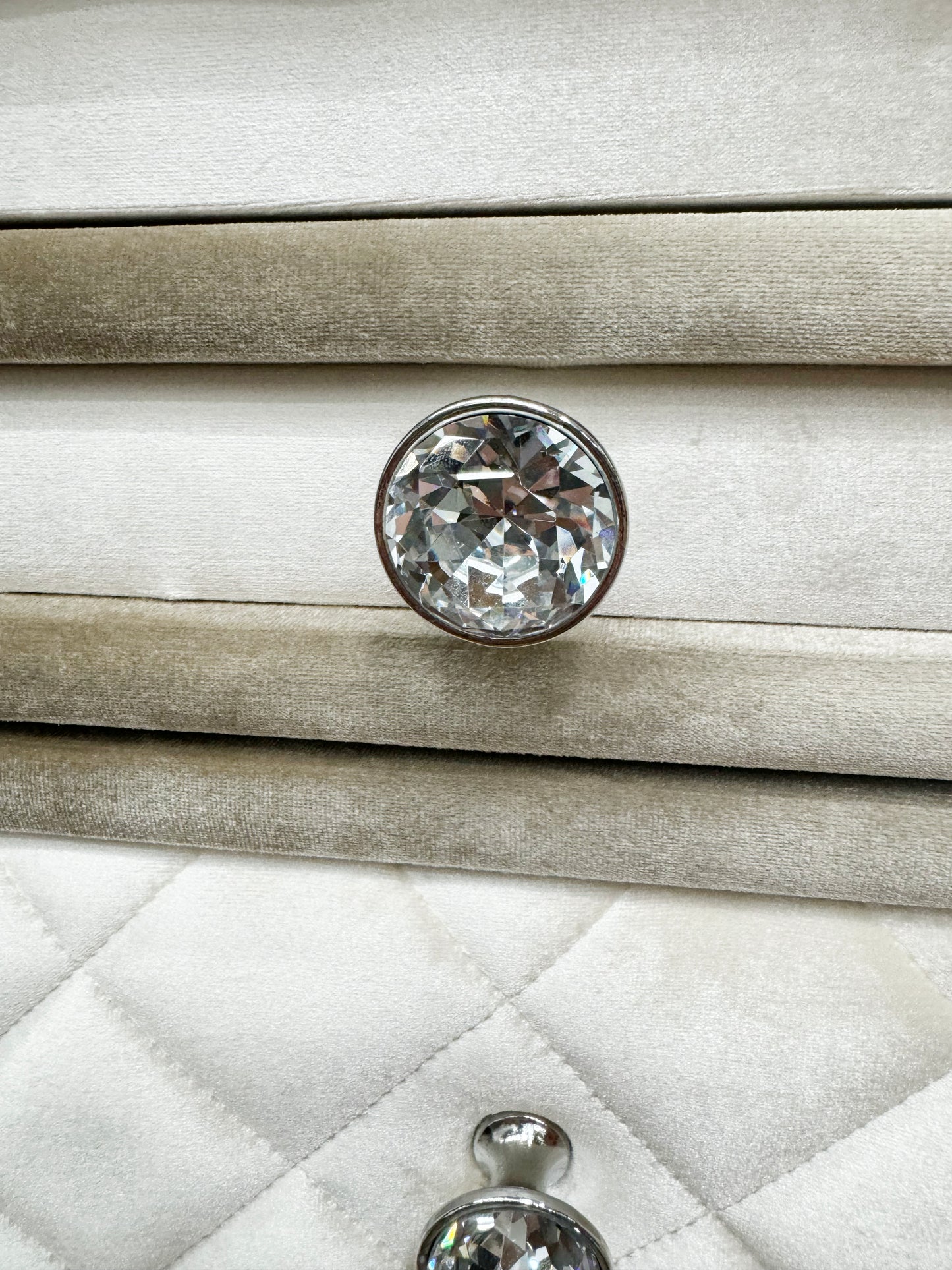 Crystal drawer knob on plush taupe upholstered furniture