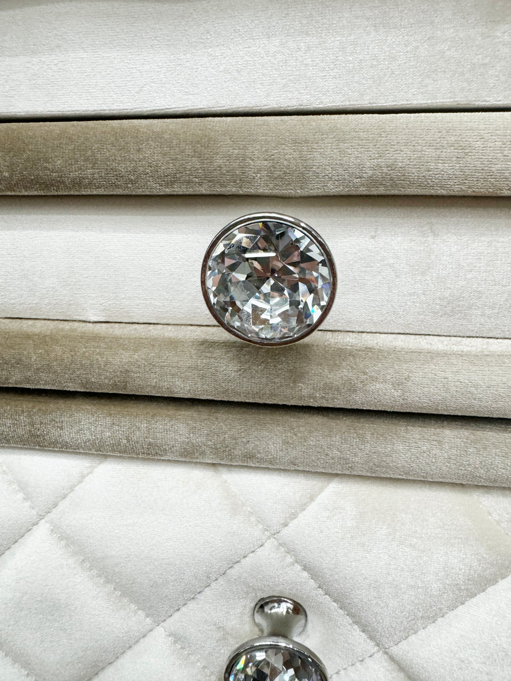 Crystal drawer knob on plush taupe upholstered furniture