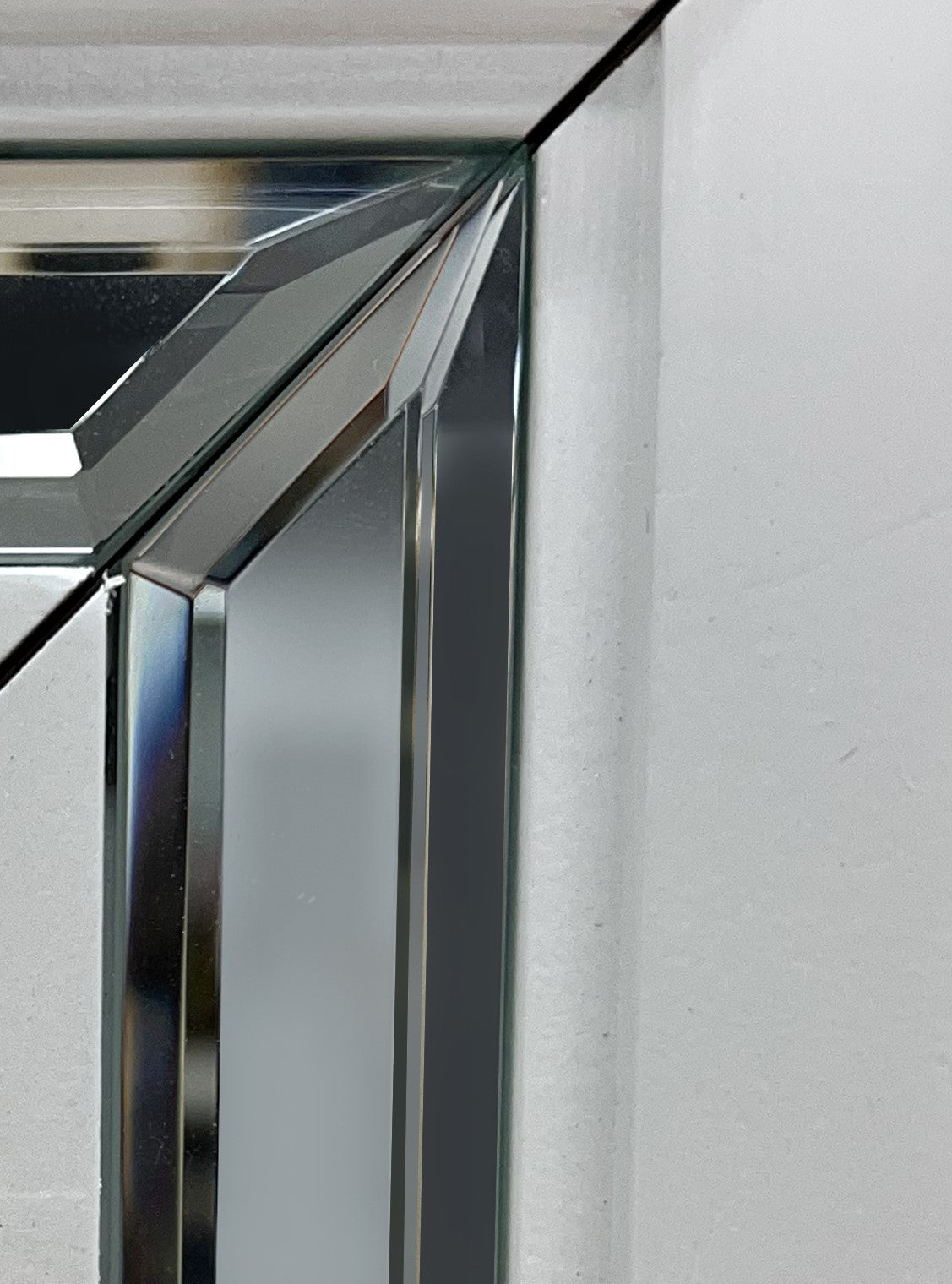 Closeup of a beveled glass mirror frame with silver accents
