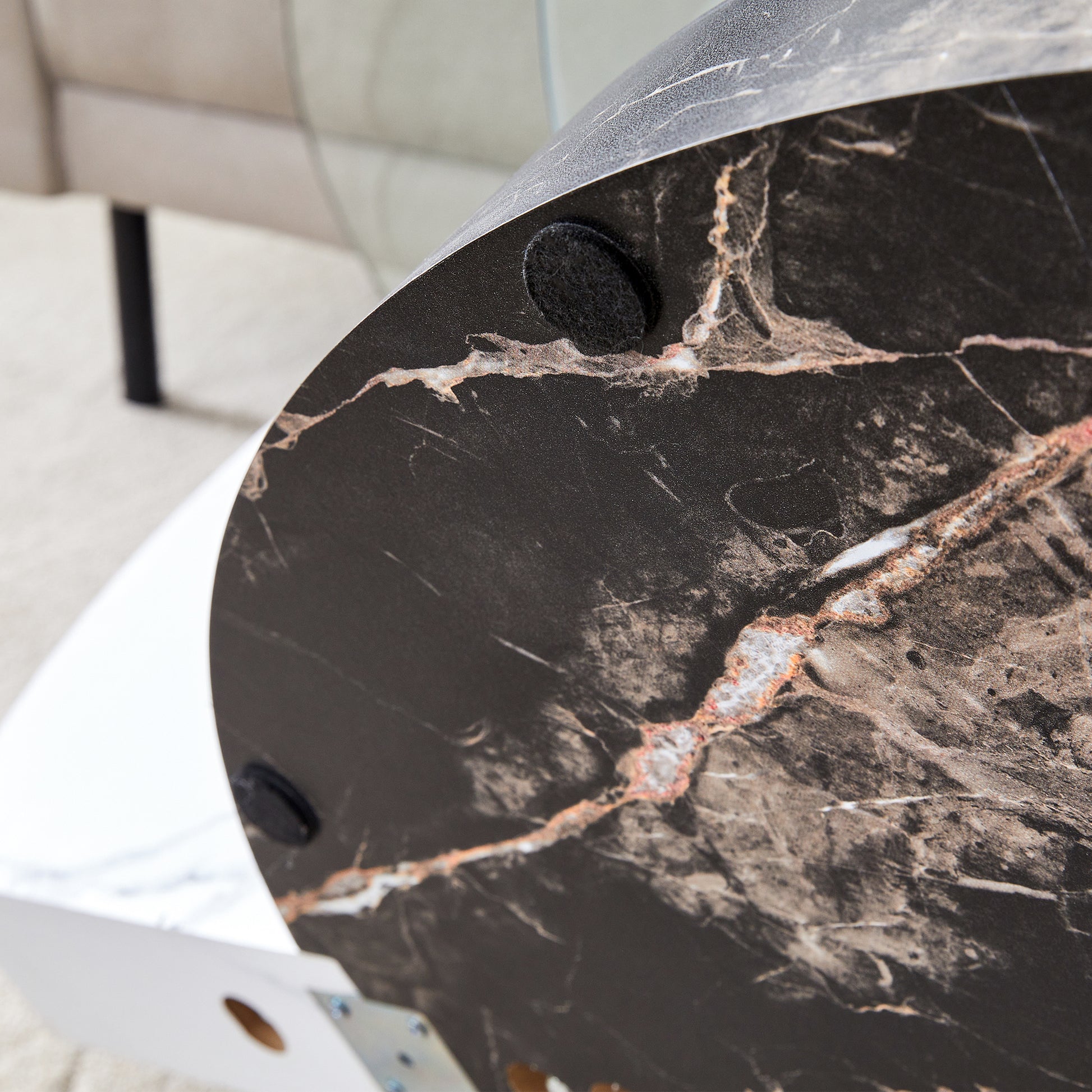 Closeup of round black marble table top with white veining and gold accents