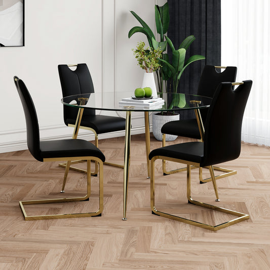 Round glass dining table with four black velvet chairs and gold frames