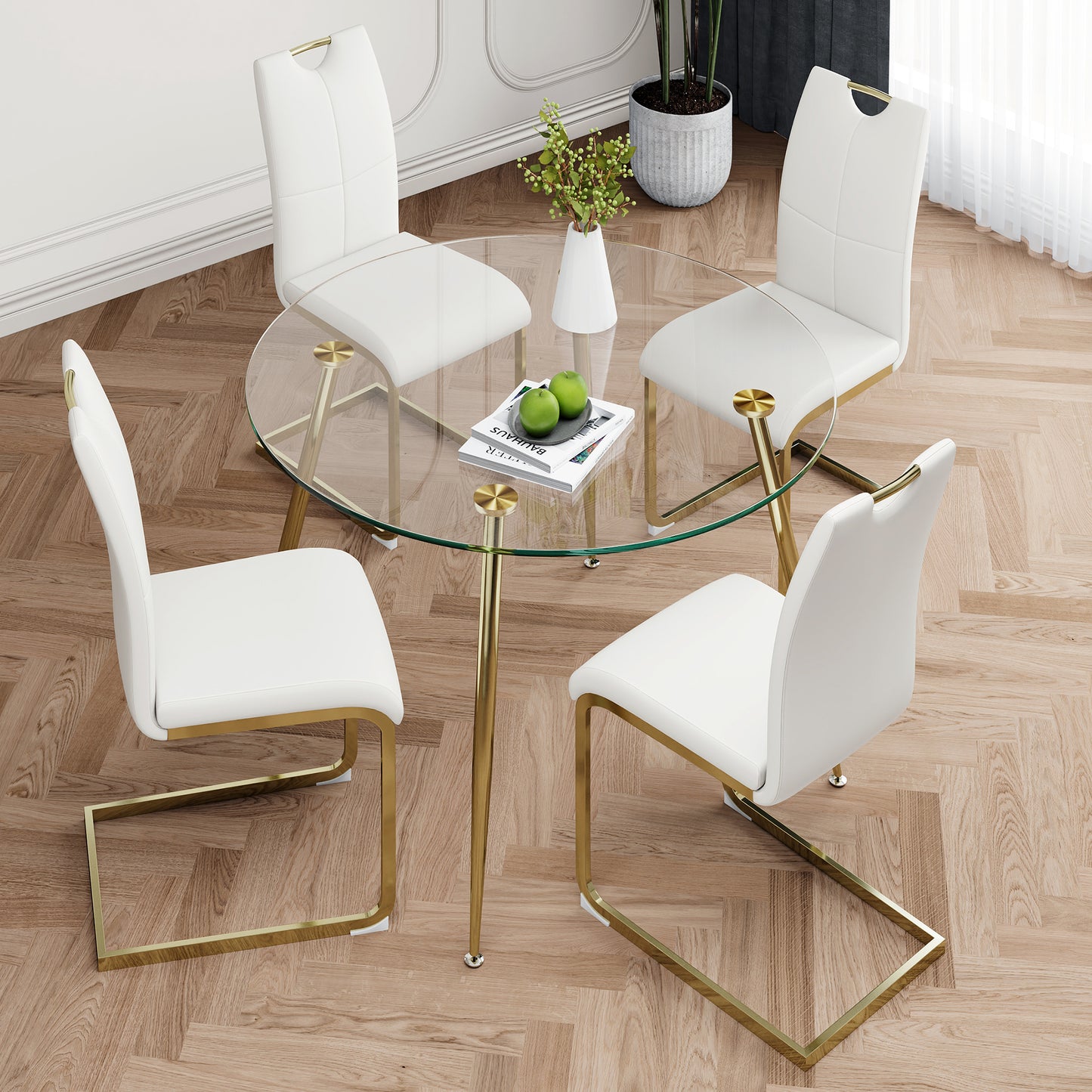 Round glass dining table with four white faux leather chairs with gold legs
