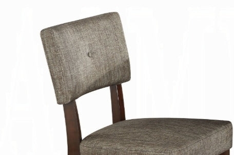 Upholstered dining chair with textured grey fabric and dark wood frame featuring button tufting on the backrest
