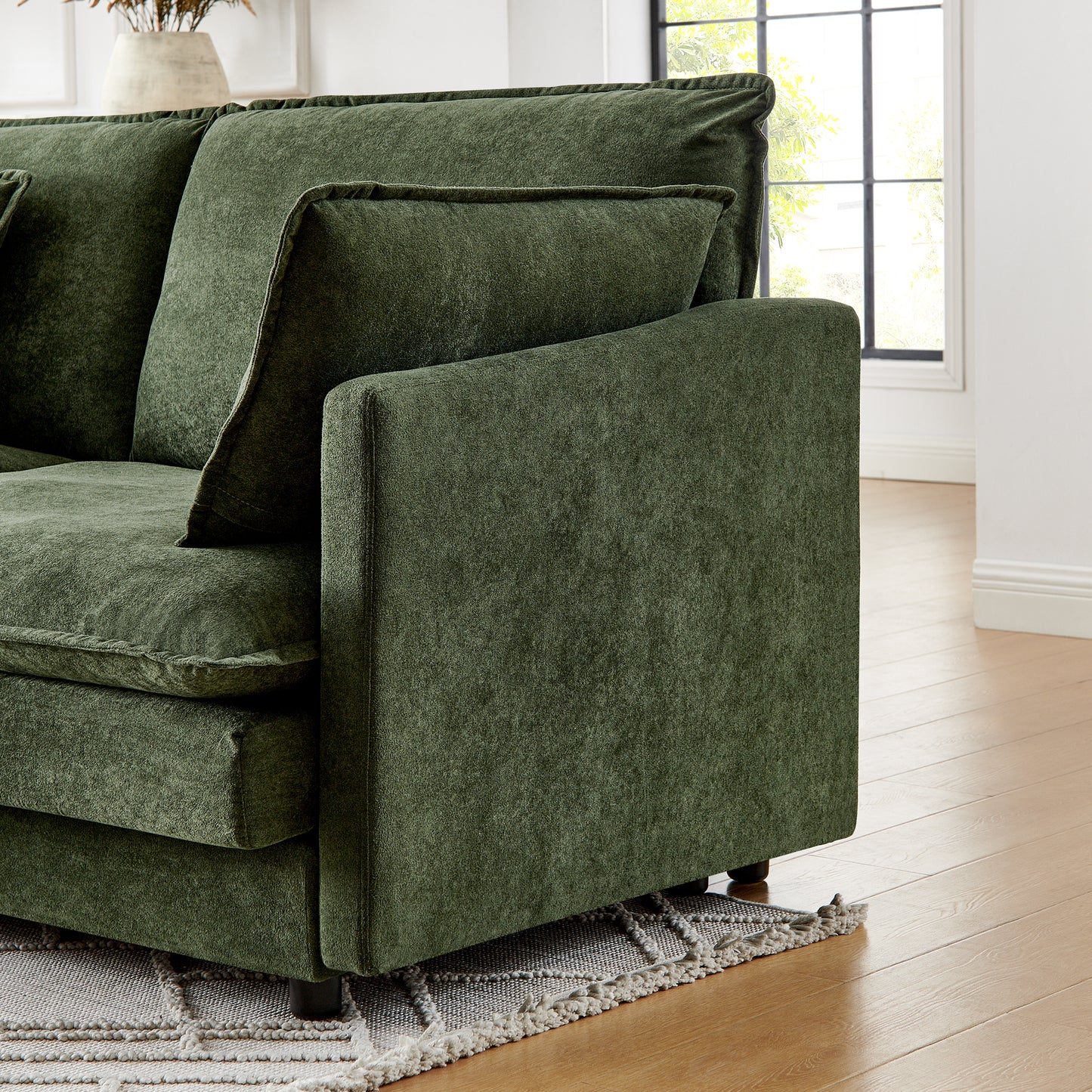 Deep green velvet sectional sofa with plush cushions and visible stitching detail