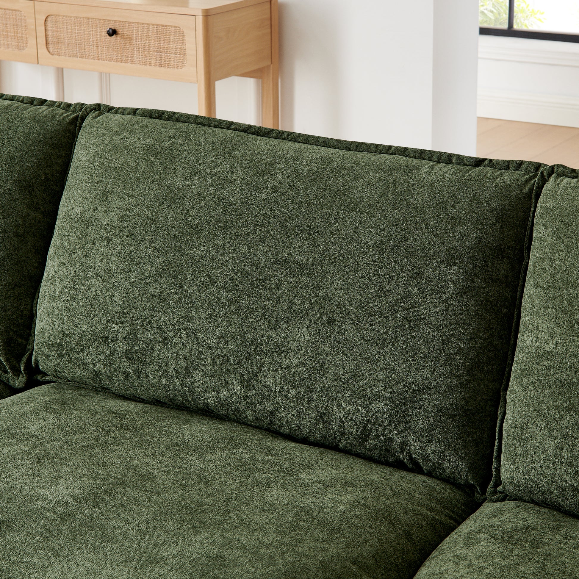 Deep green plush fabric sofa with textured cushions for luxurious comfort