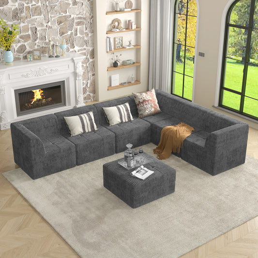 Dark gray corduroy sectional sofa with ottoman styled in a modern living room