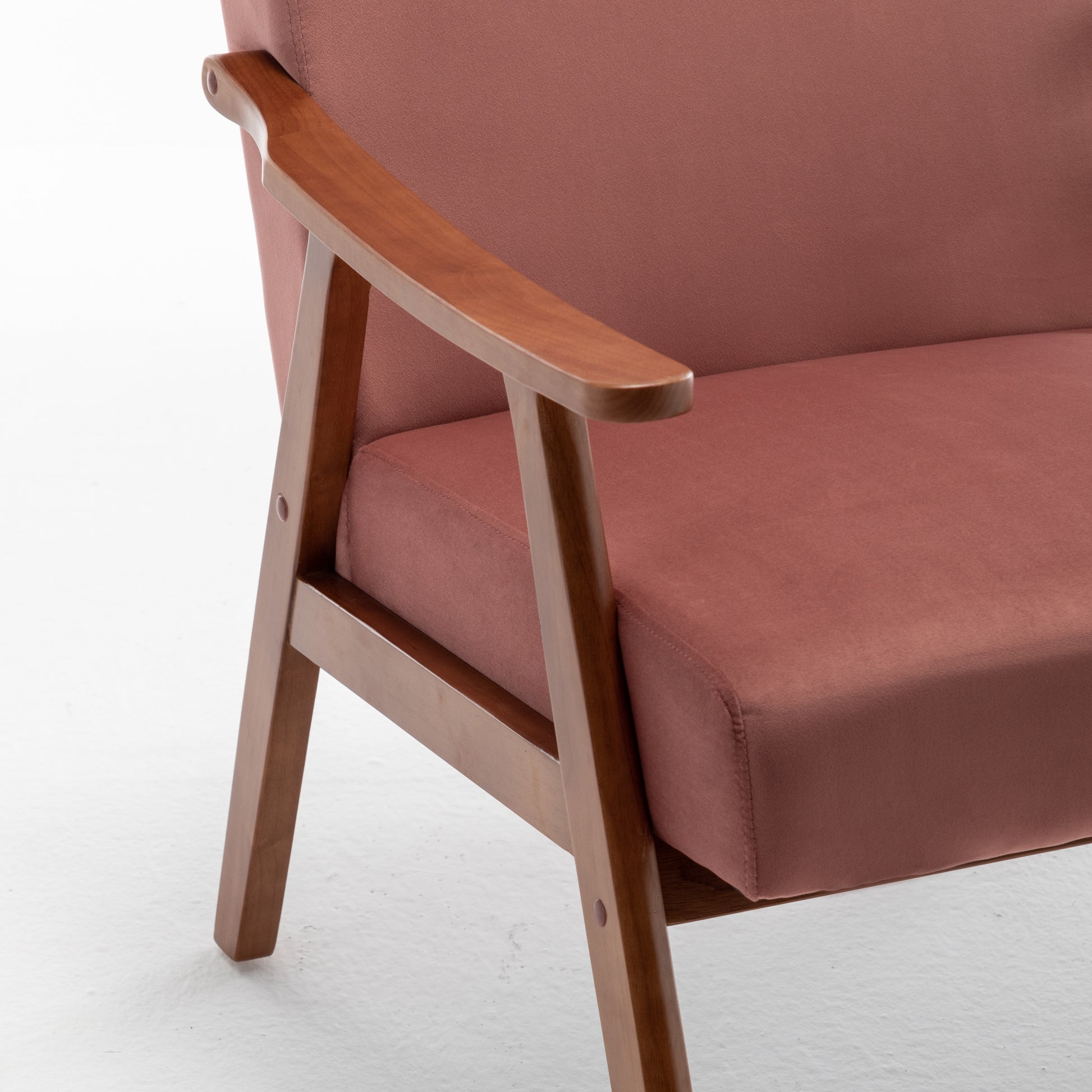 Rose pink upholstered armchair with wooden armrests and legs