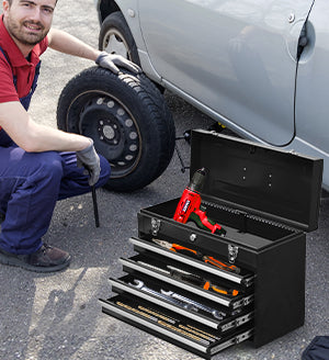 Black metal toolbox with open drawers filled with wrenches and a cordless drill