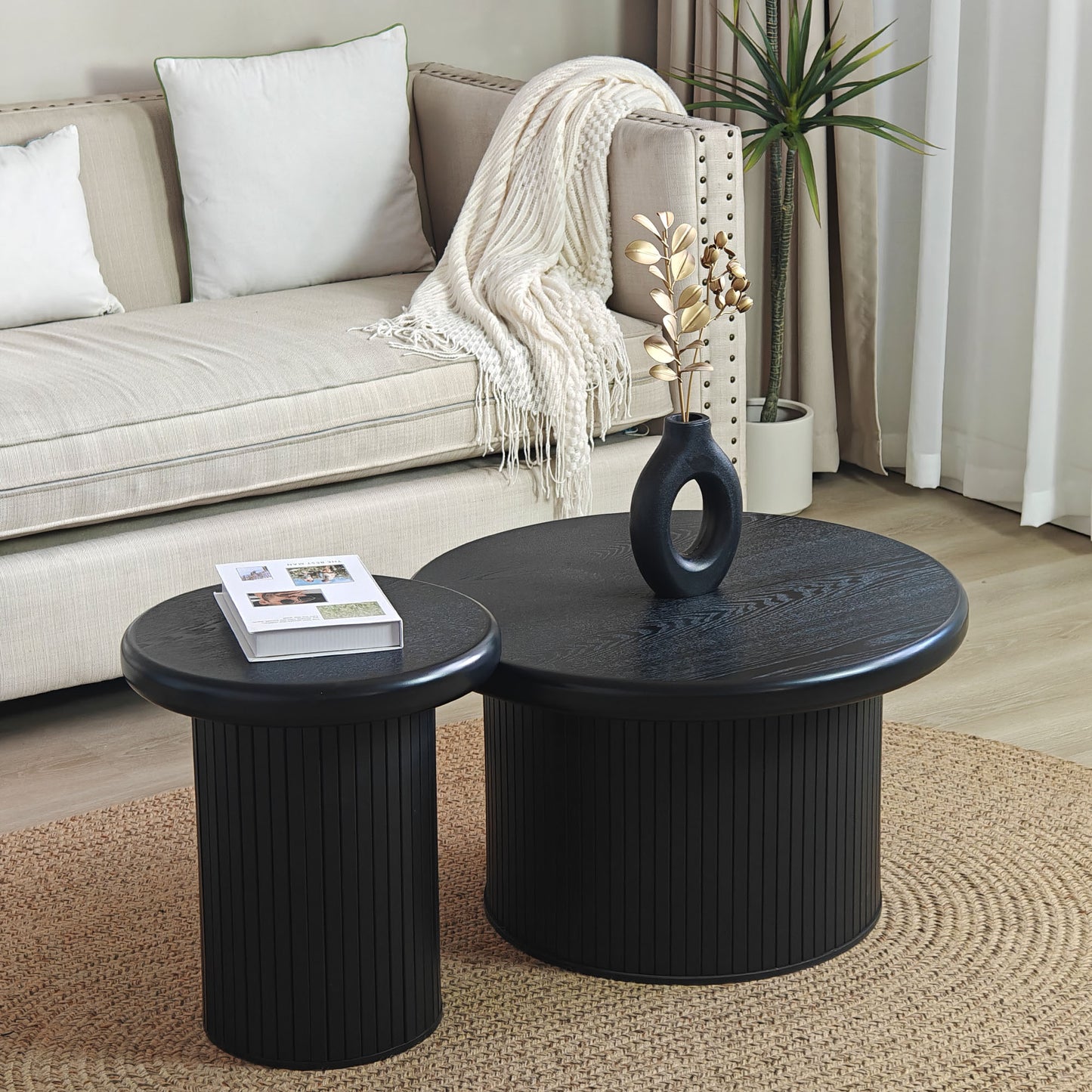 Pair of black fluted drum coffee tables with textured wood grain surface