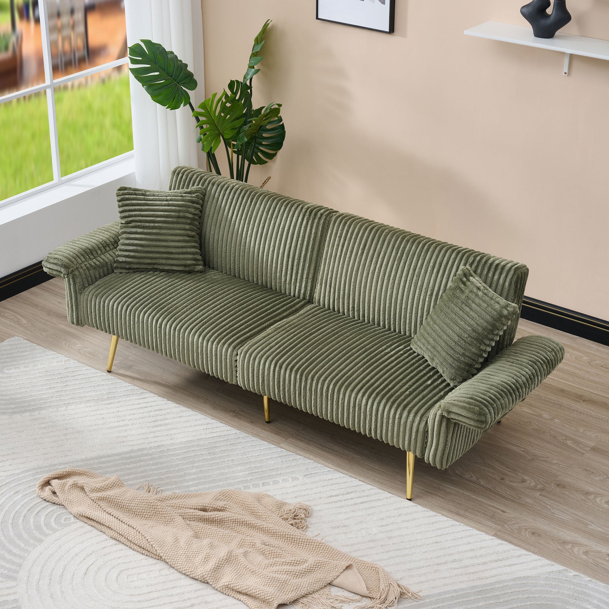 Sage green corduroy sofa with tufted detailing and gold legs