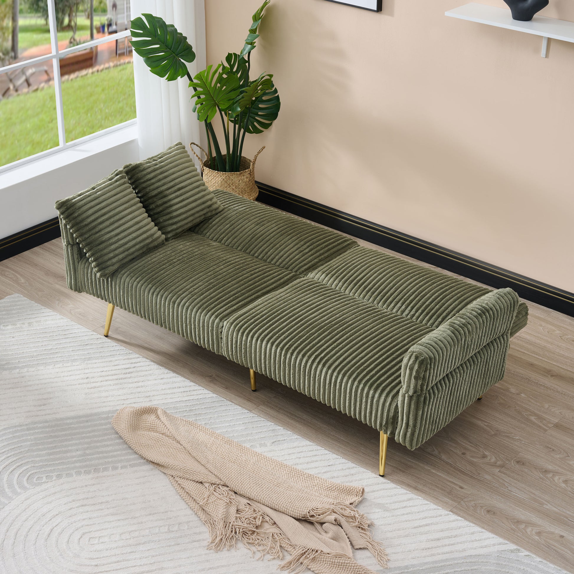 Sage green corduroy sofa bed with plush cushions and gold legs ideal for small apartments