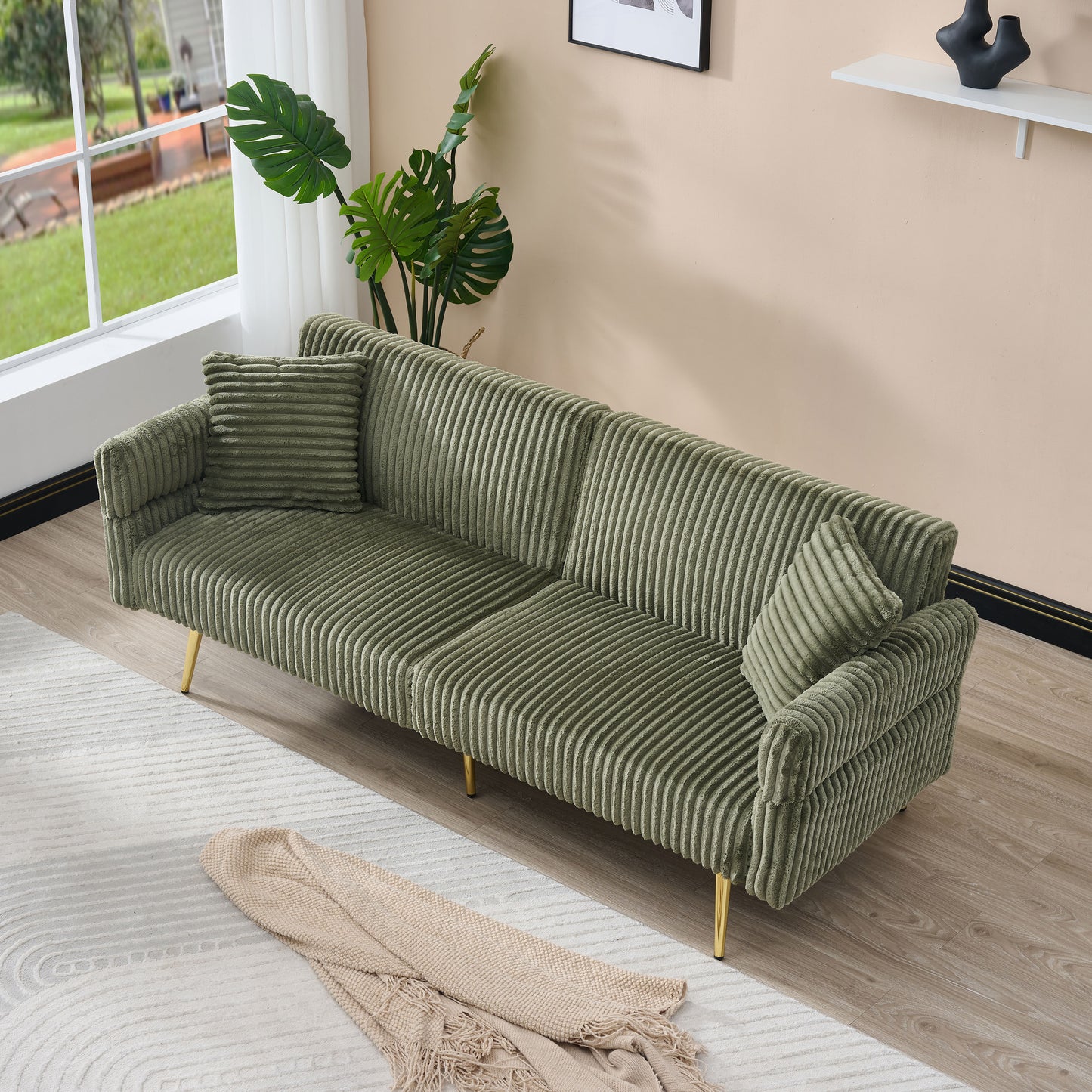 Plush green corduroy sofa with gold legs and matching throw pillows perfect for modern living rooms