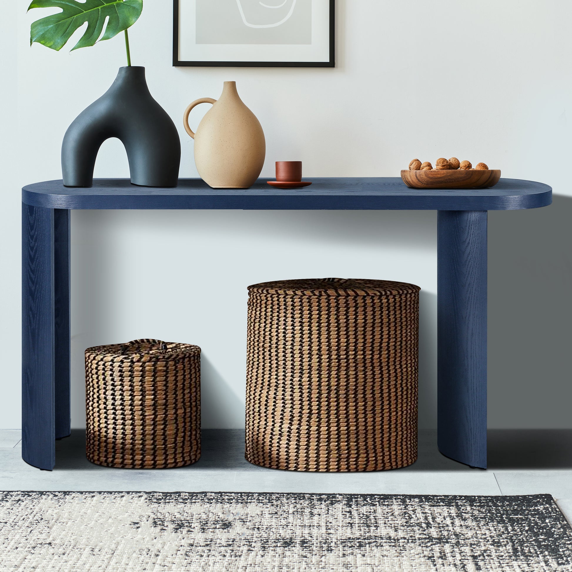 Dark blue modern console table with curved legs holding decorative vases
