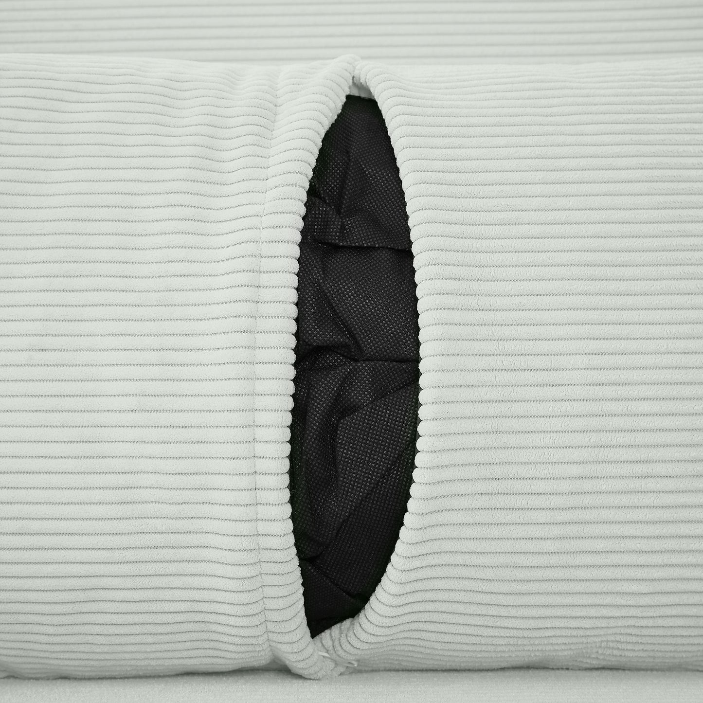 Closeup of light grey corduroy fabric with a visible black interior liner