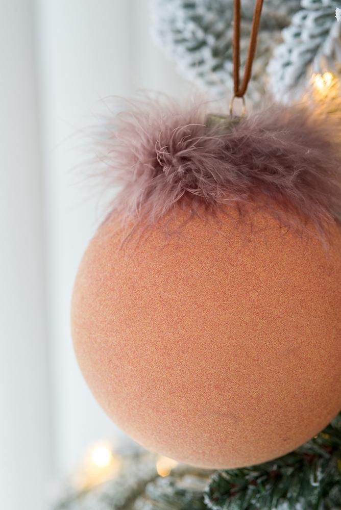 Textured peach Christmas ornament with delicate feather trim perfect for tree decor