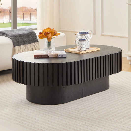 Dark oak oval coffee table with fluted sides and a modern silhouette