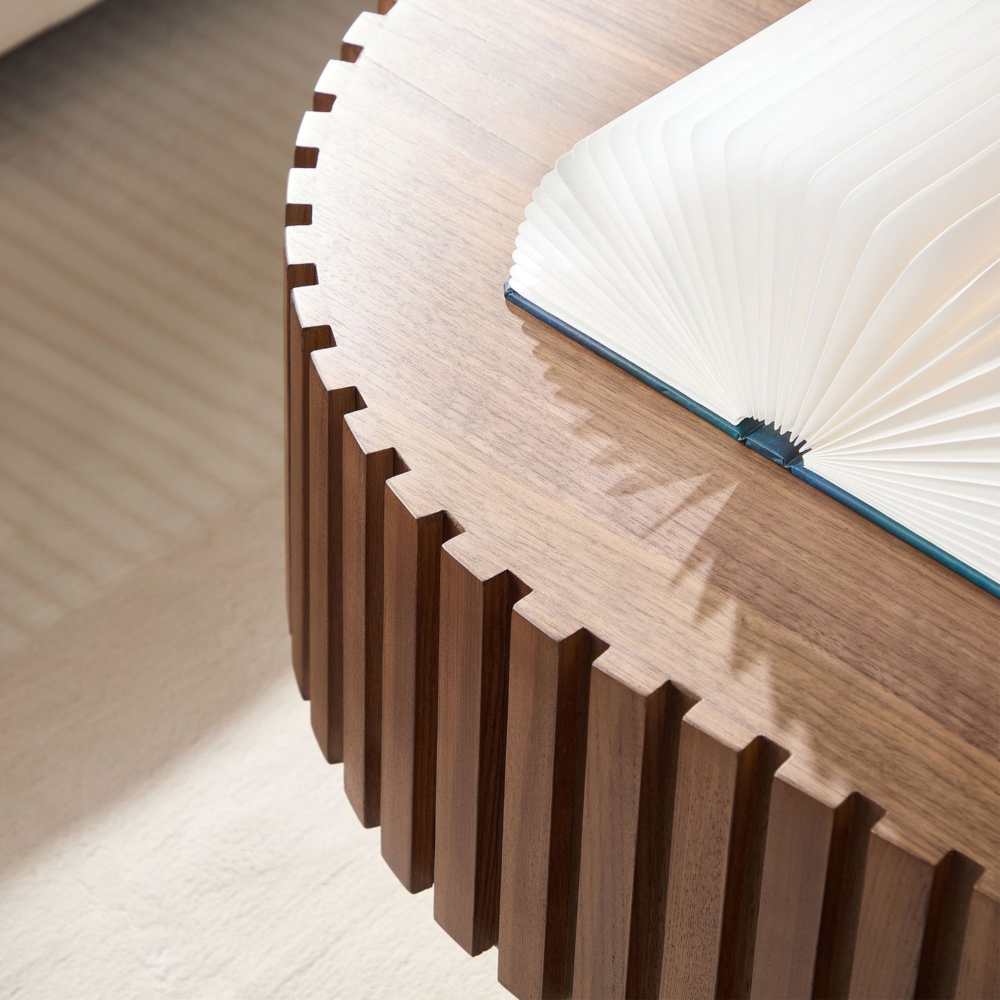 Wooden side table with a fluted design and a book with fanfolded pages