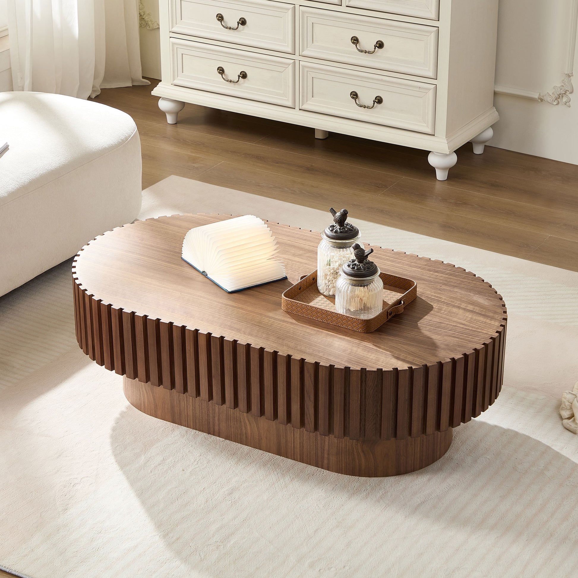Oval walnut coffee table with fluted design and a minimalist aesthetic