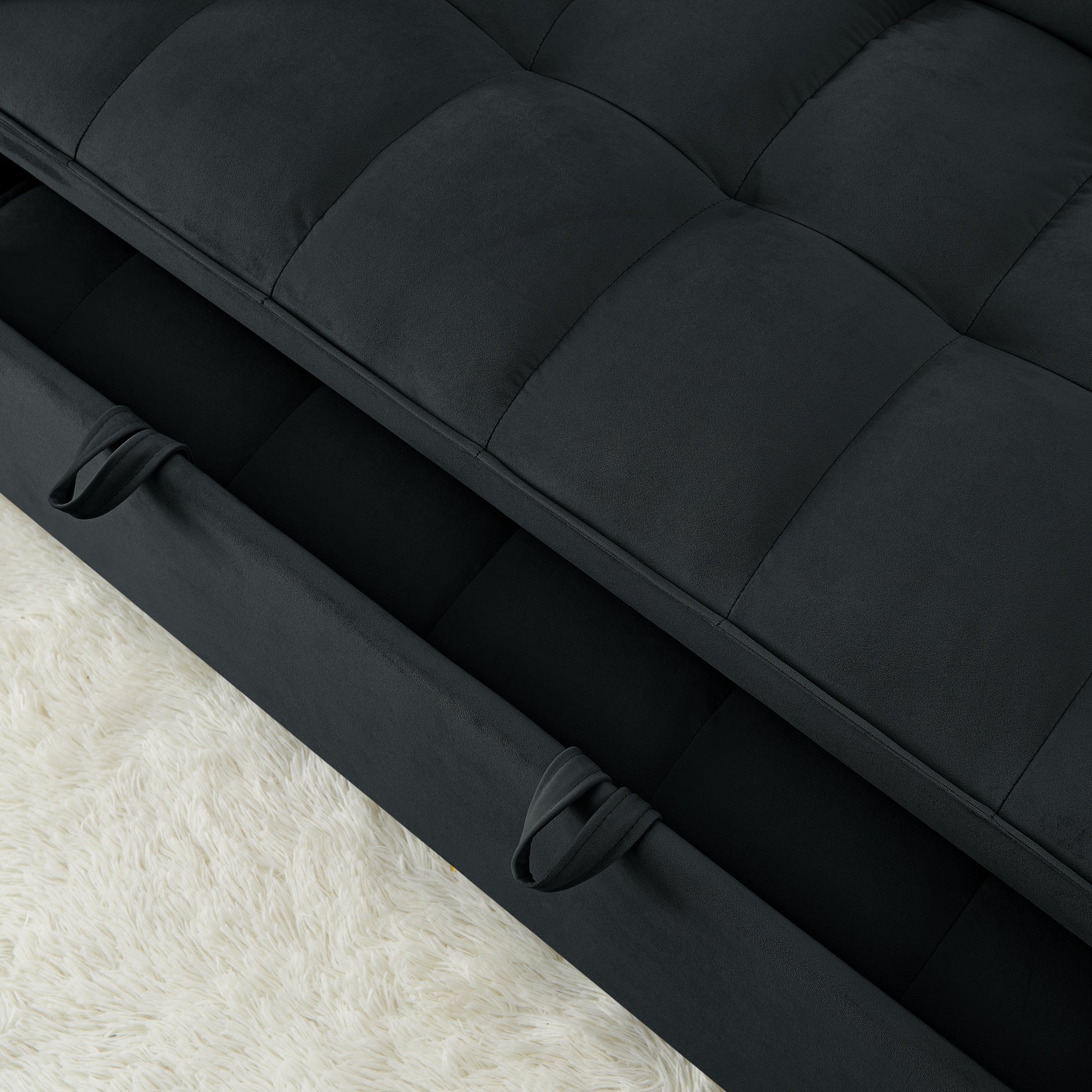 Tufted dark gray sofa with pullout storage drawer and fabric handle