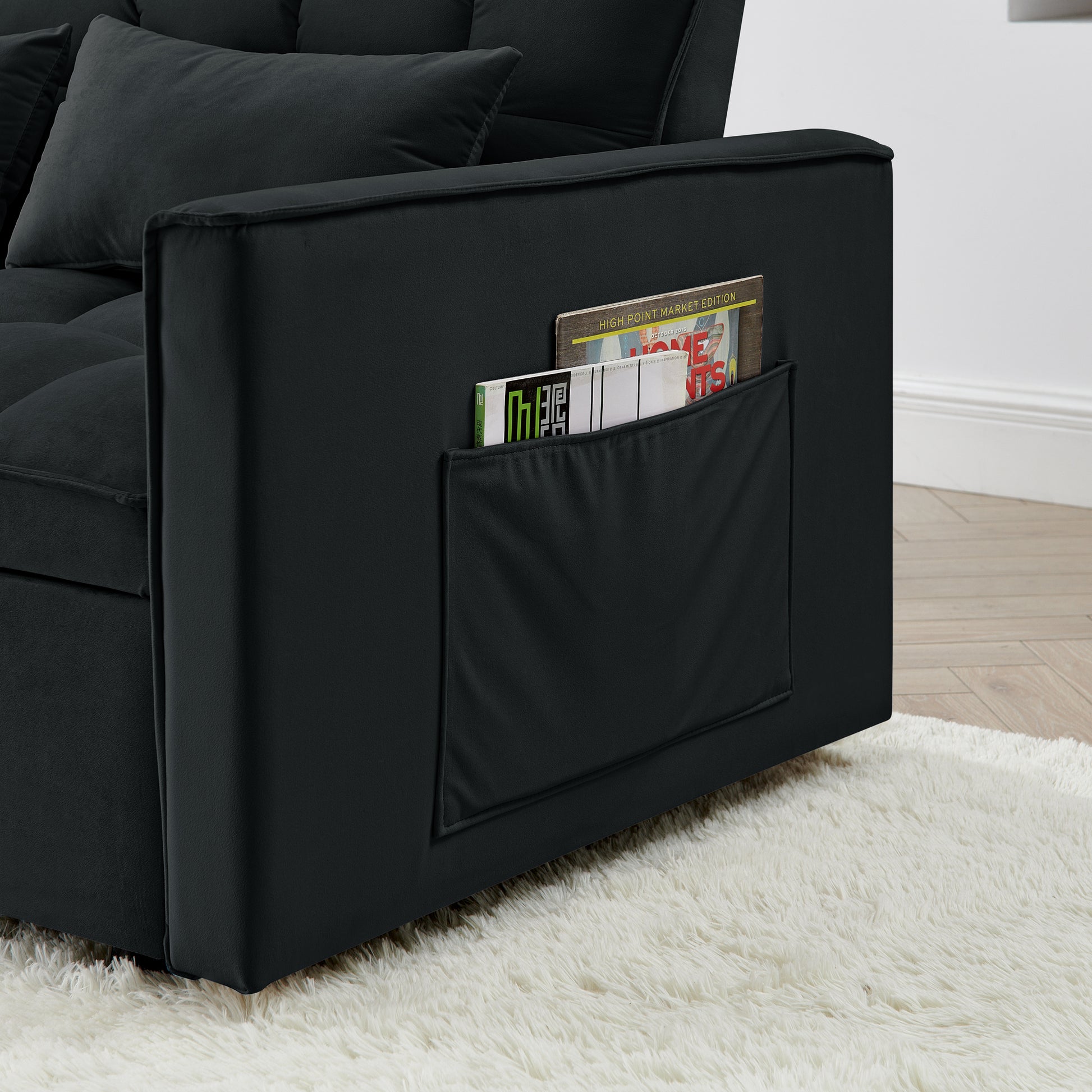 Black velvet sofa with builtin side pocket storing magazines