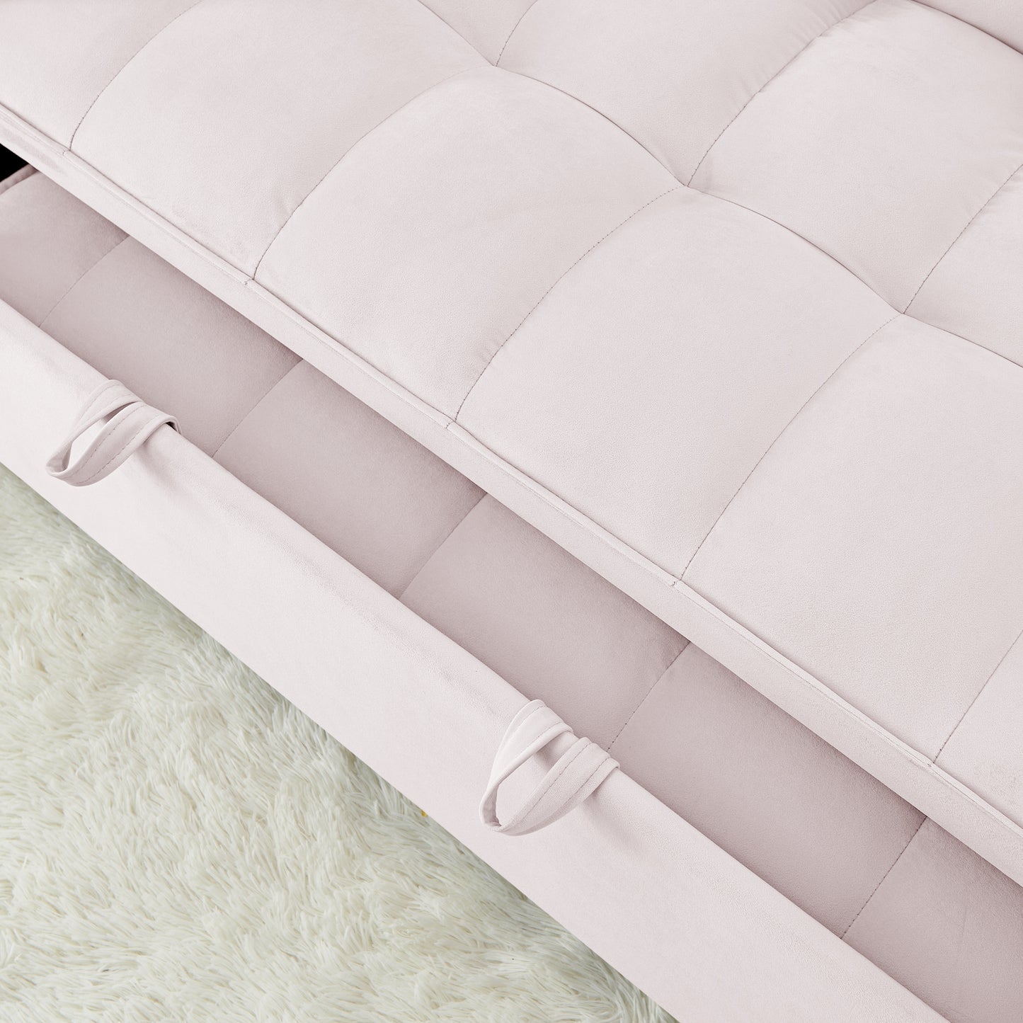 Closeup of a plush pink velvet sofa with tufted cushions and pulltabs showing texture